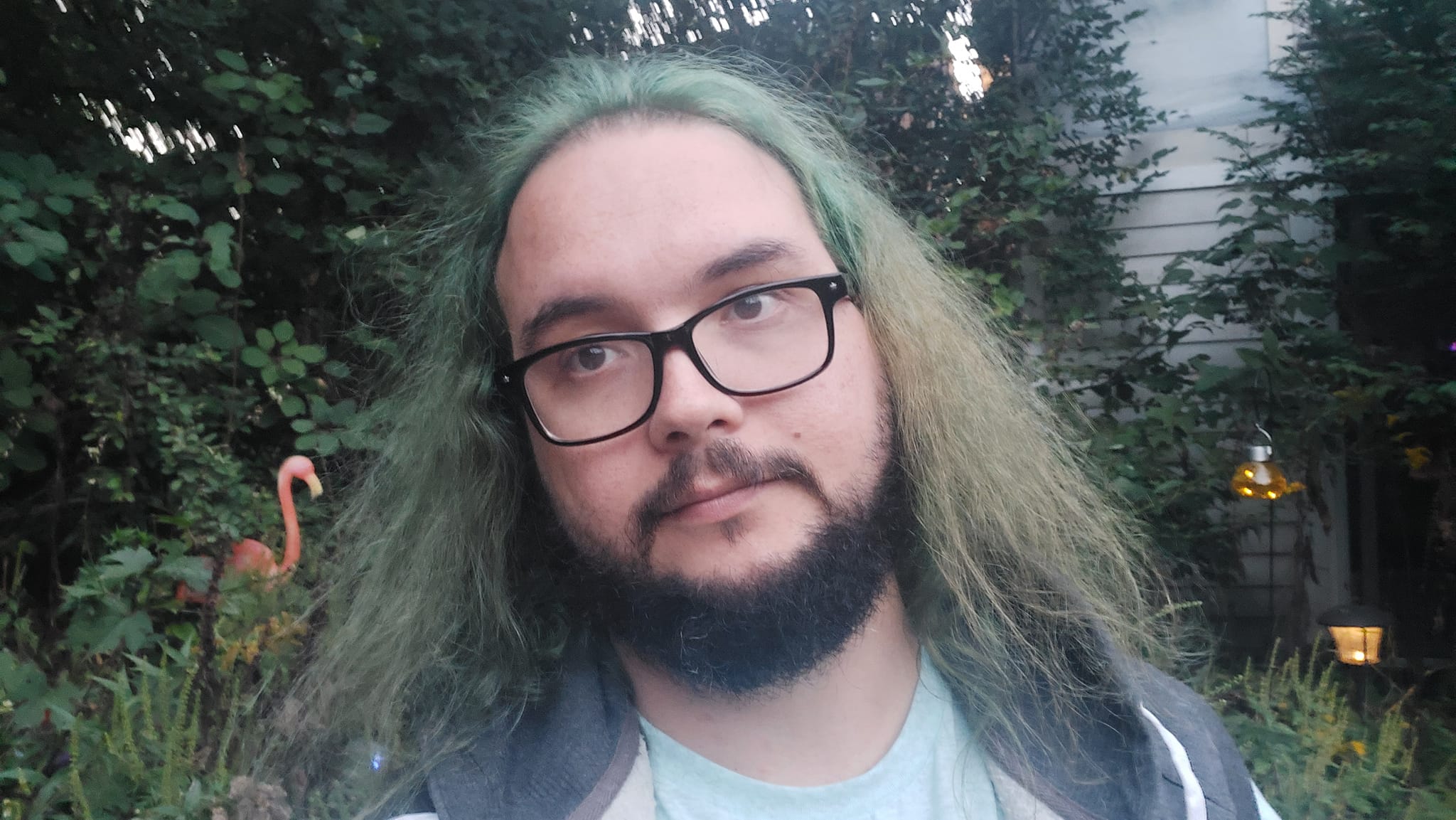 A man with green hair and a beard is outside after dark, Photo 1